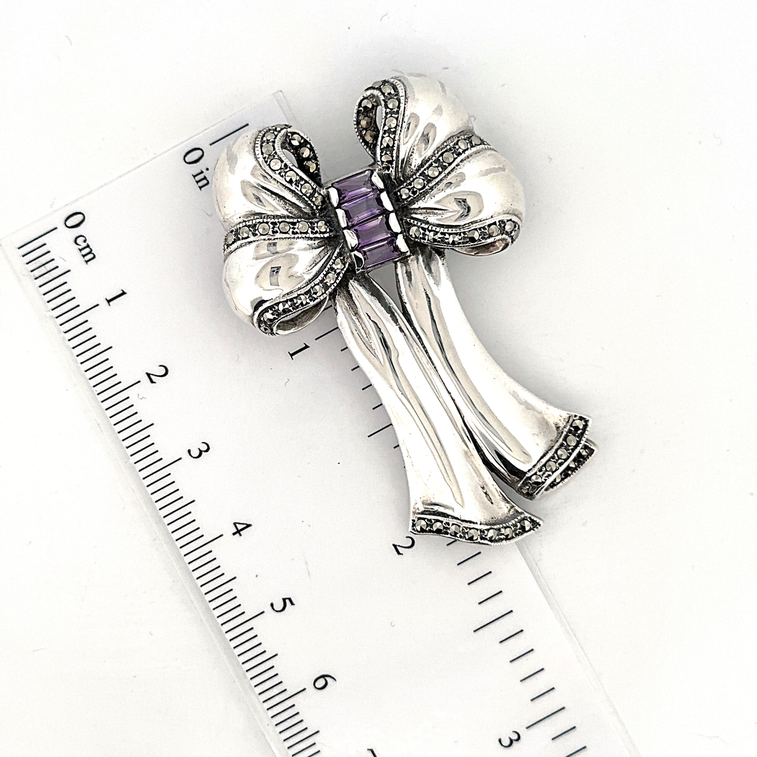 B351 (11) Bow Pin Brooch With Amethyst And Marcasite Finished In 925 English Hallmarked Sterling Silver