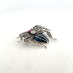 Side angle of a spider brooch with blue enamel, marcasite and crystals in sterling silver