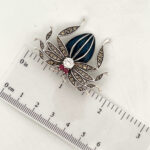 Spider brooch with enamel, marcasite and crystals, shown with a ruler for dimensions